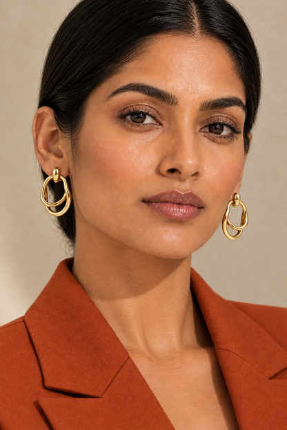 Closer portrait of the model in a burnt orange suit wearing the earrings