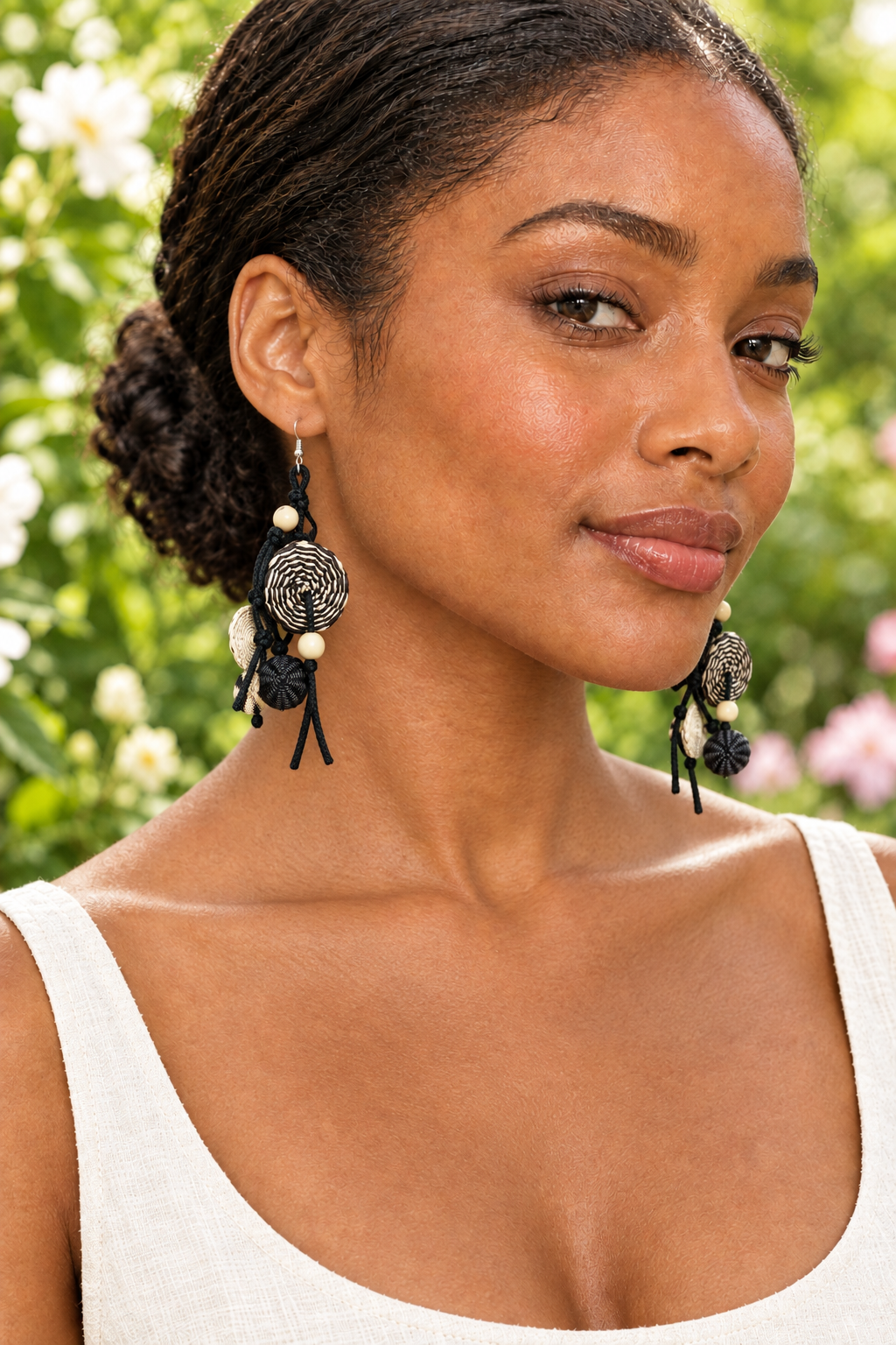 Garden portrait of the previous model wearing the black-and-cream earrings