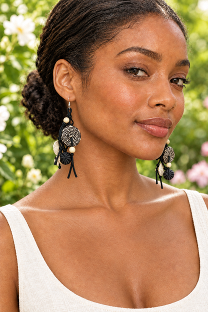 Garden portrait of the previous model wearing the black-and-cream earrings
